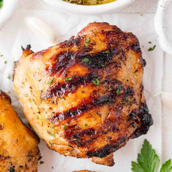 Grilled chicken thigh on top of parchment paper.