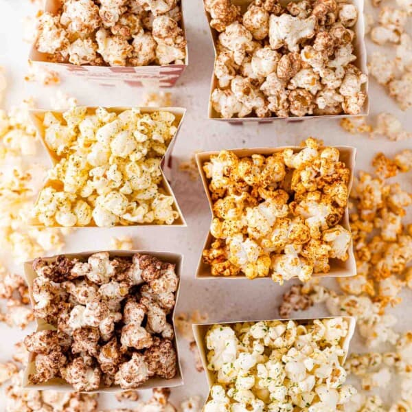 Overhead view of six different types of popcorn seasoning.