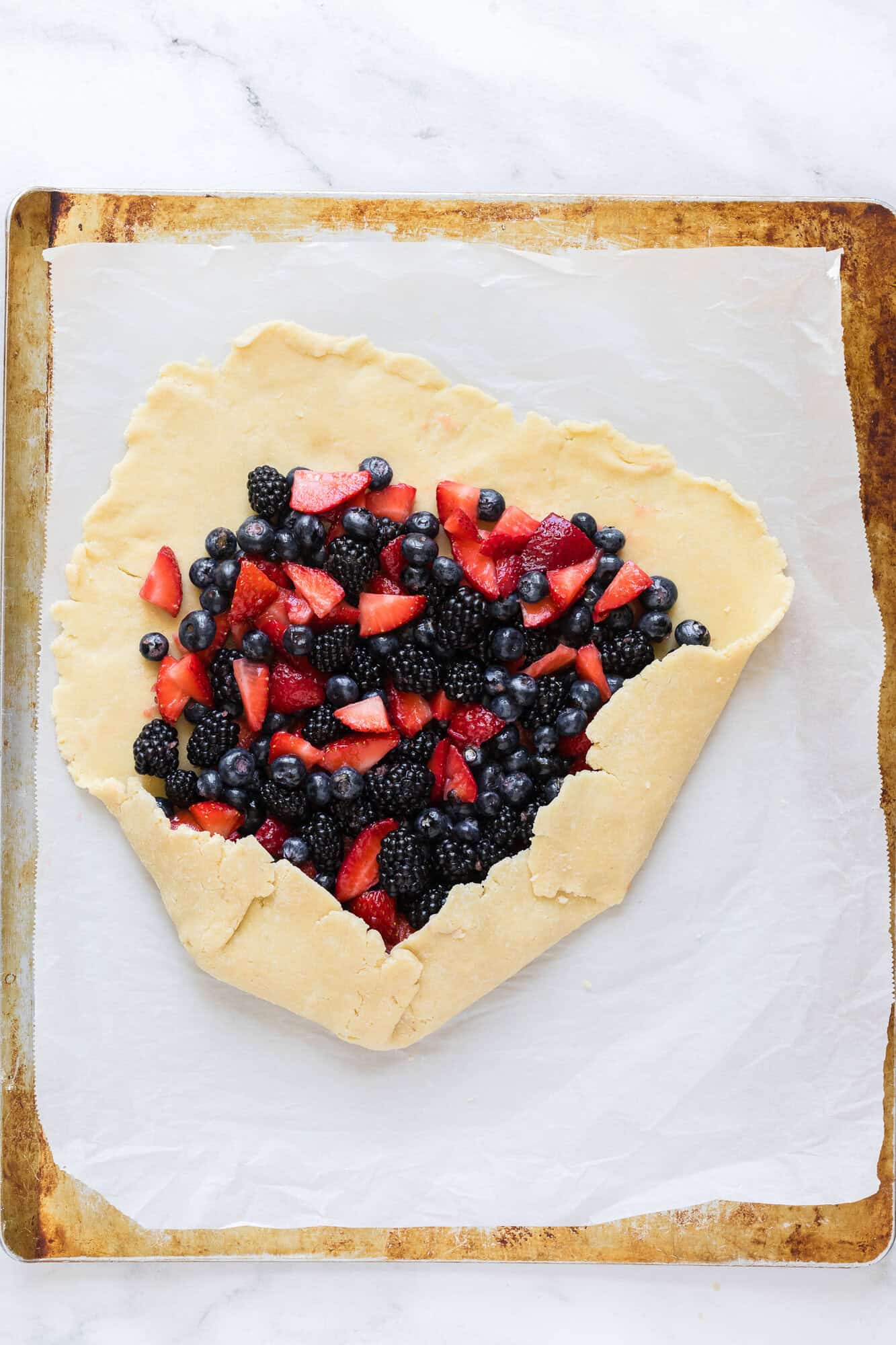 Pie crust partially folded over berry filling.