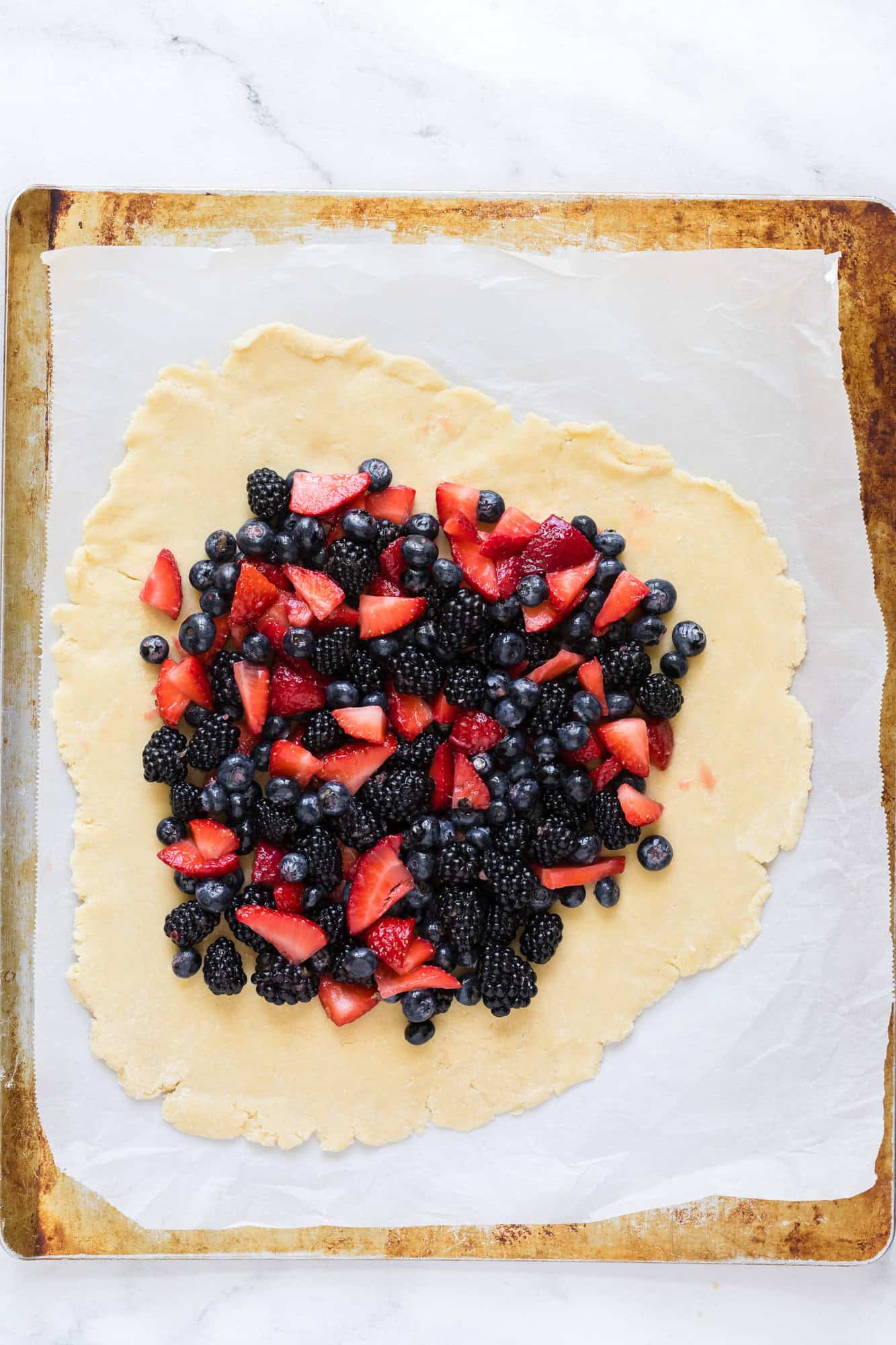 Berries added to pie crust, crust not yet folded over.