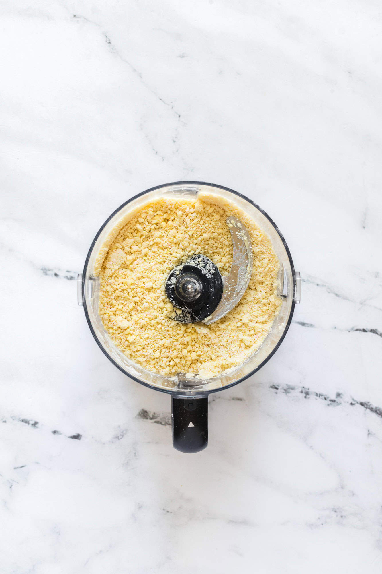 Pie crust prepared in a food processor, viewed from overhead.