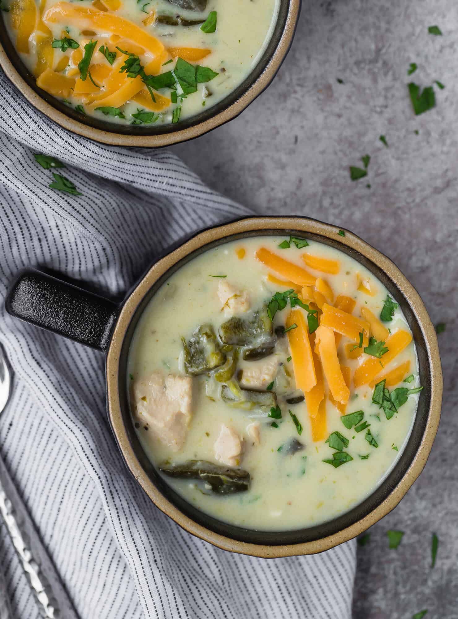 Overhead view of chile relleno soup, topped with cheddar cheese.