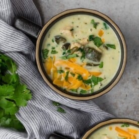Overhead view of chile relleno soup, topped with cheddar cheese.