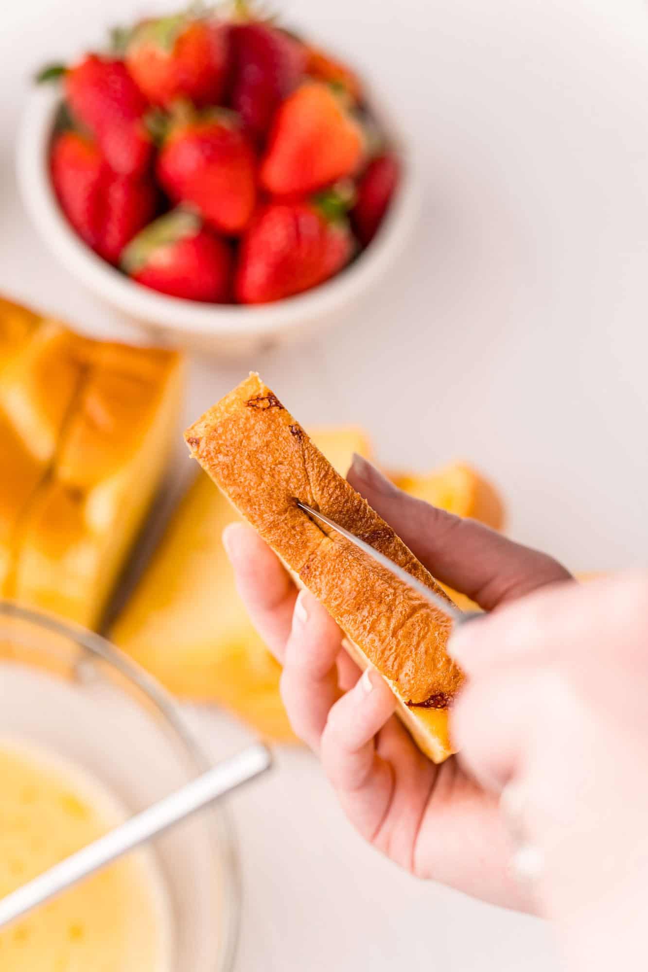 Slit being cut in bread for filling.