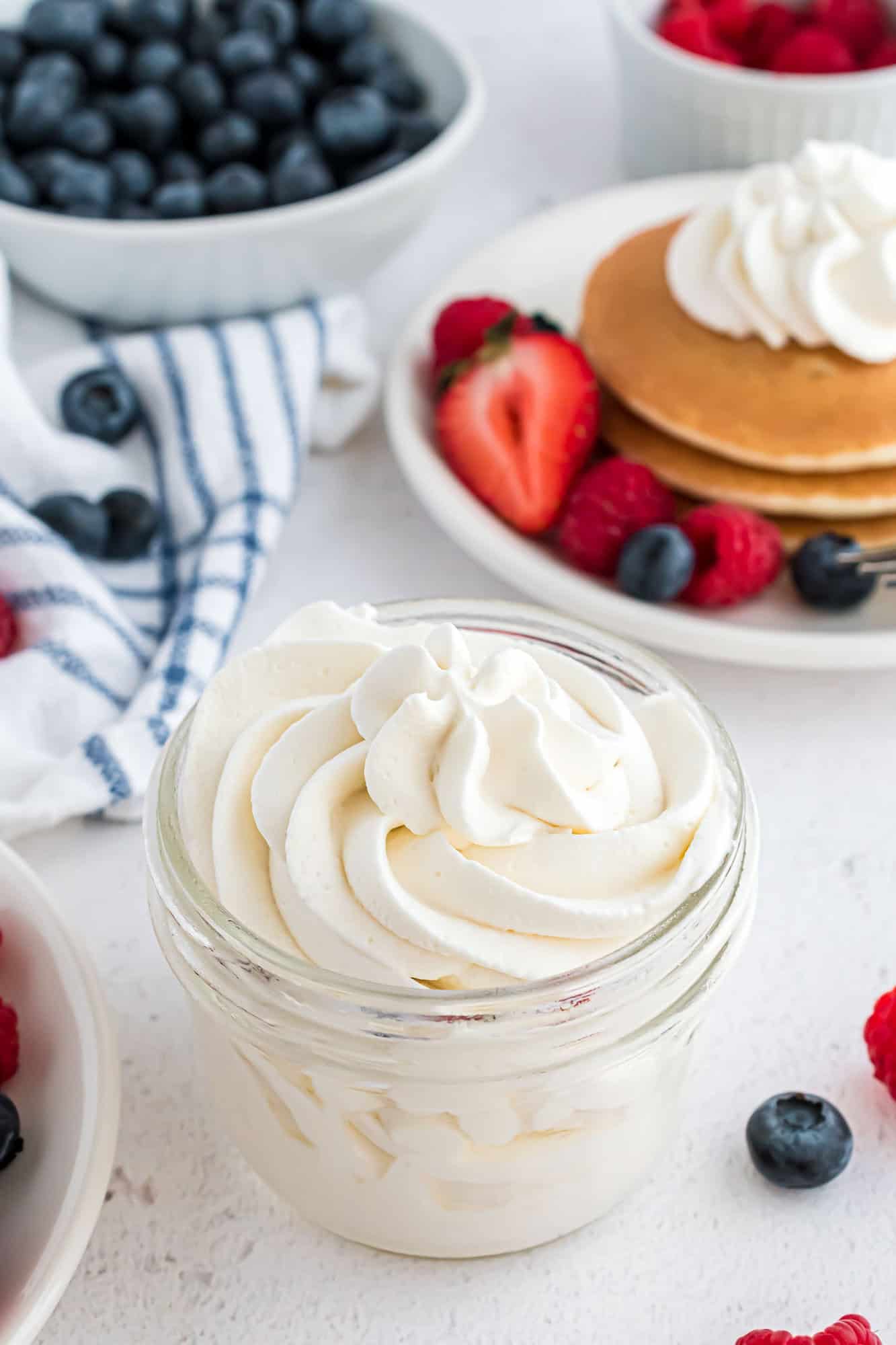 Homemade whipped cream in a small glass jar.