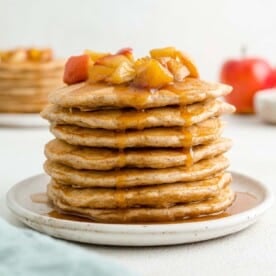 Tall stack of apple pancakes, topped with apple compote.