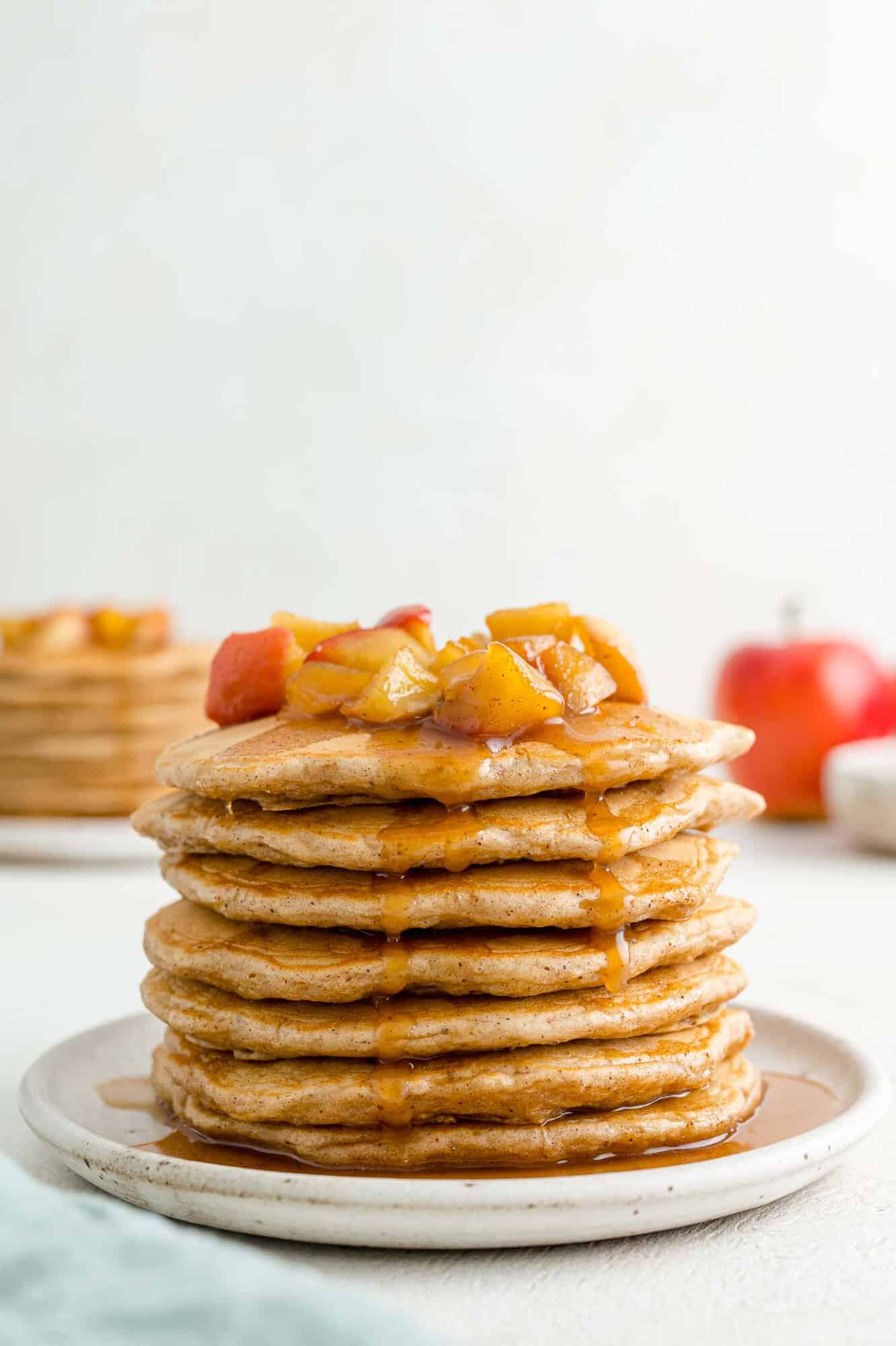 Tall stack of apple pancakes, topped with apple compote.