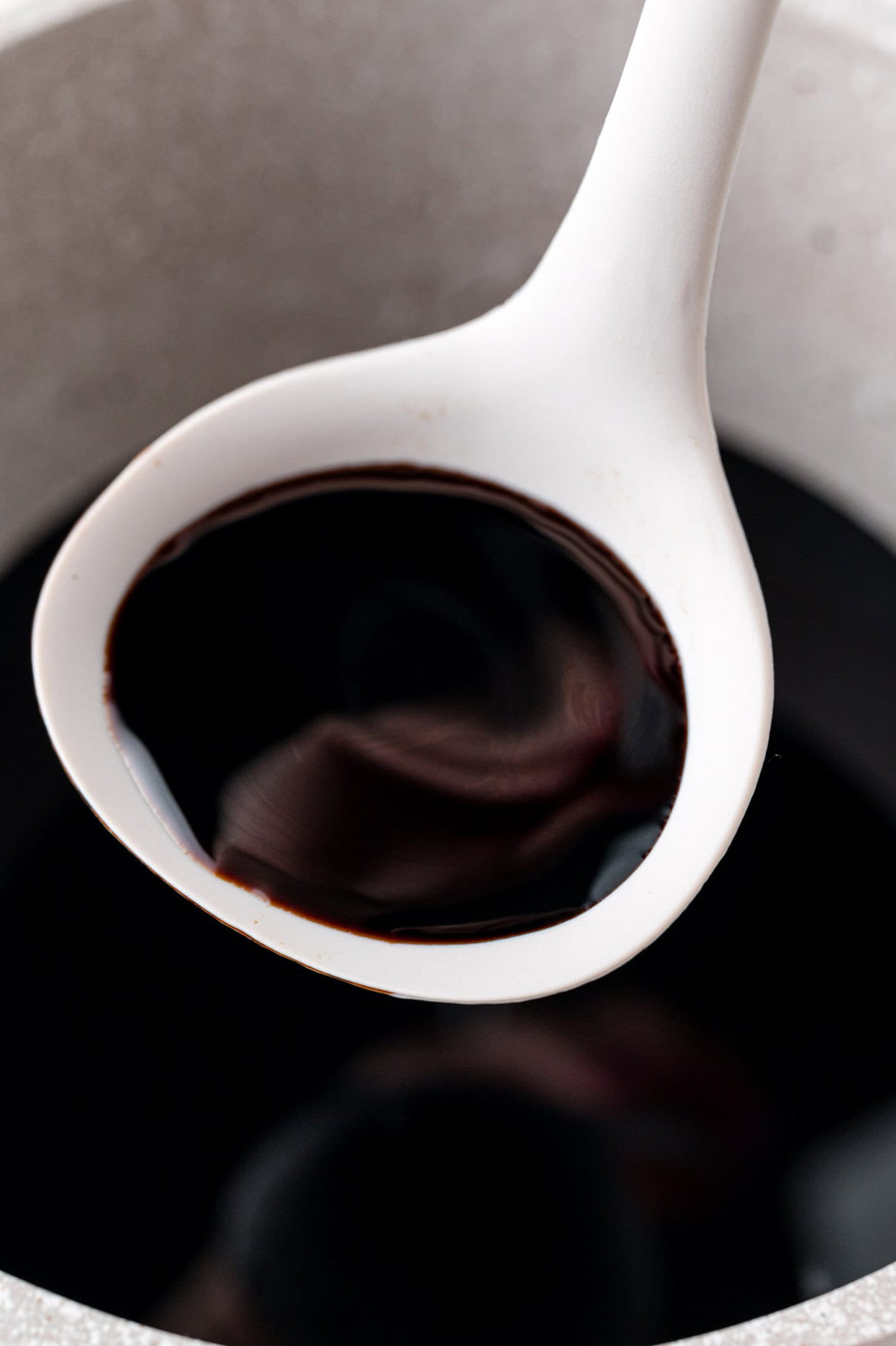 Balsamic glaze in a small ladle.