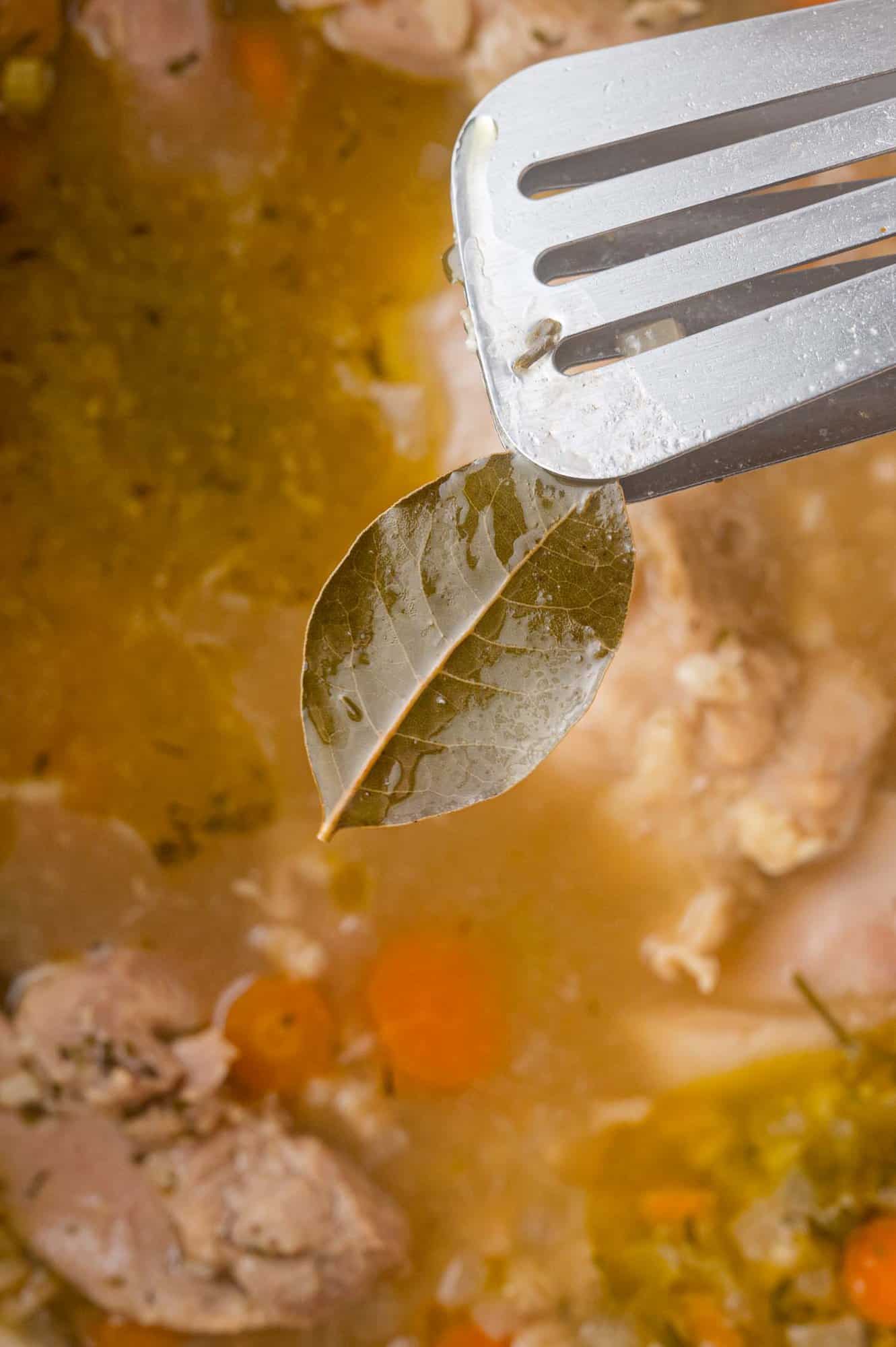 Bay leaf being removed from soup.