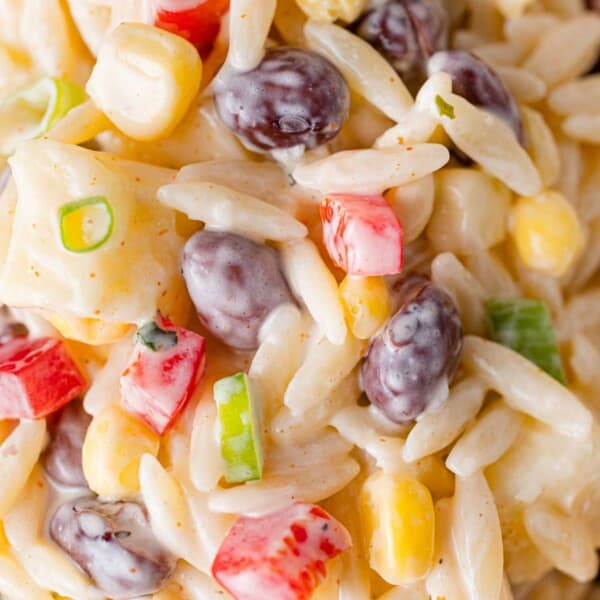 Close up view of creamy southwestern orzo salad with black beans, corn, peppers.