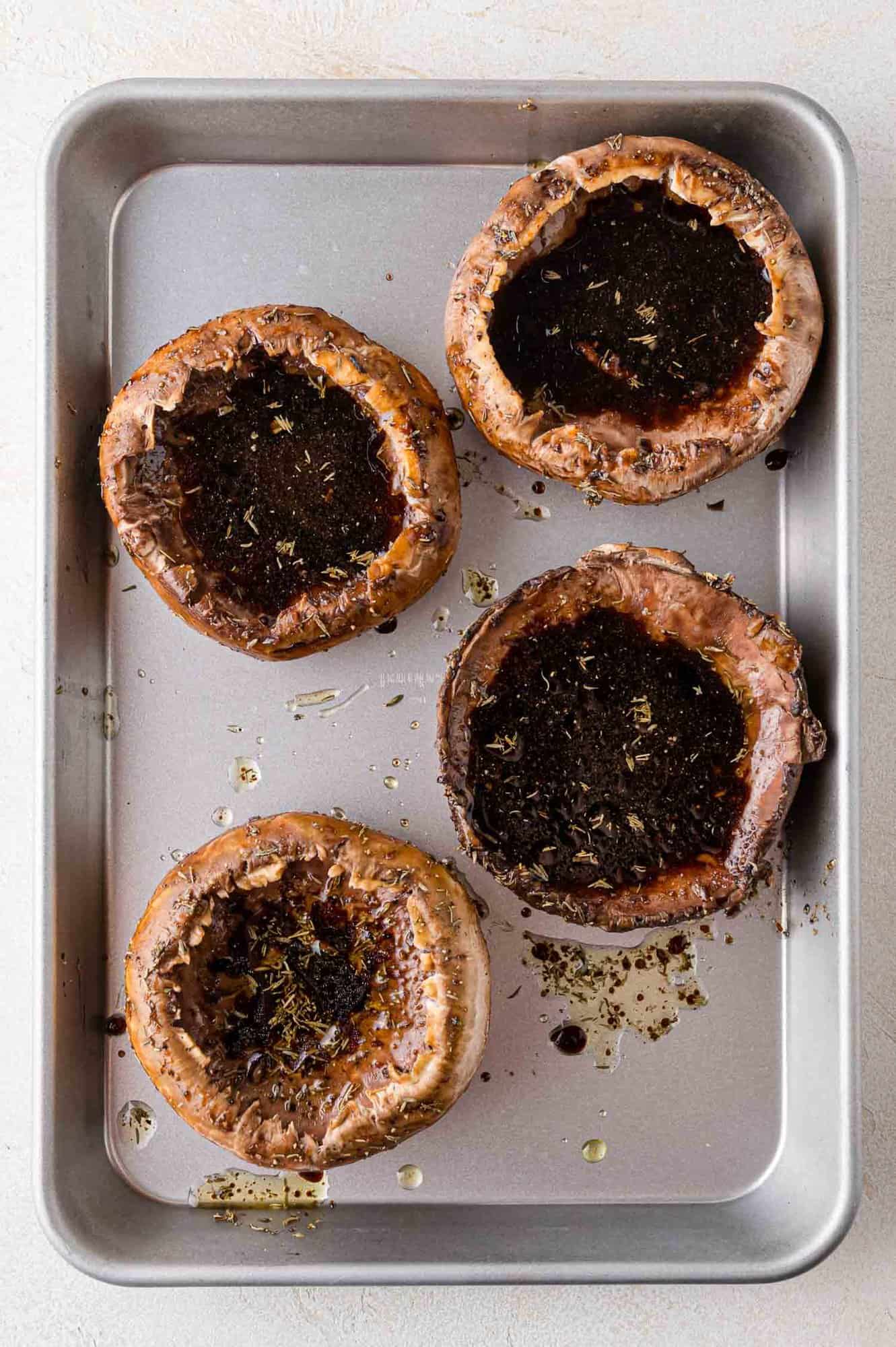 Mushrooms marinating on a sheet pan.