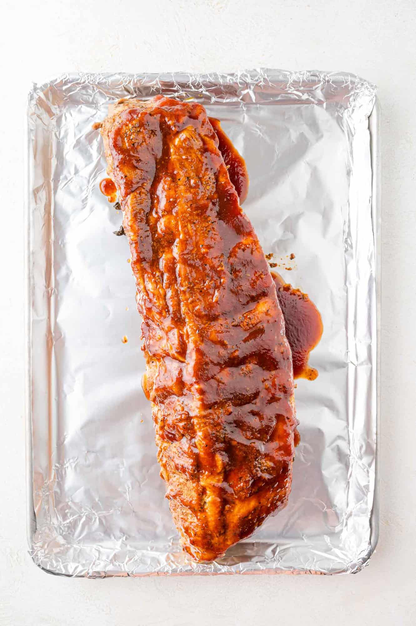 Ribs on a foil-lined baking sheet, ready to be broiled.