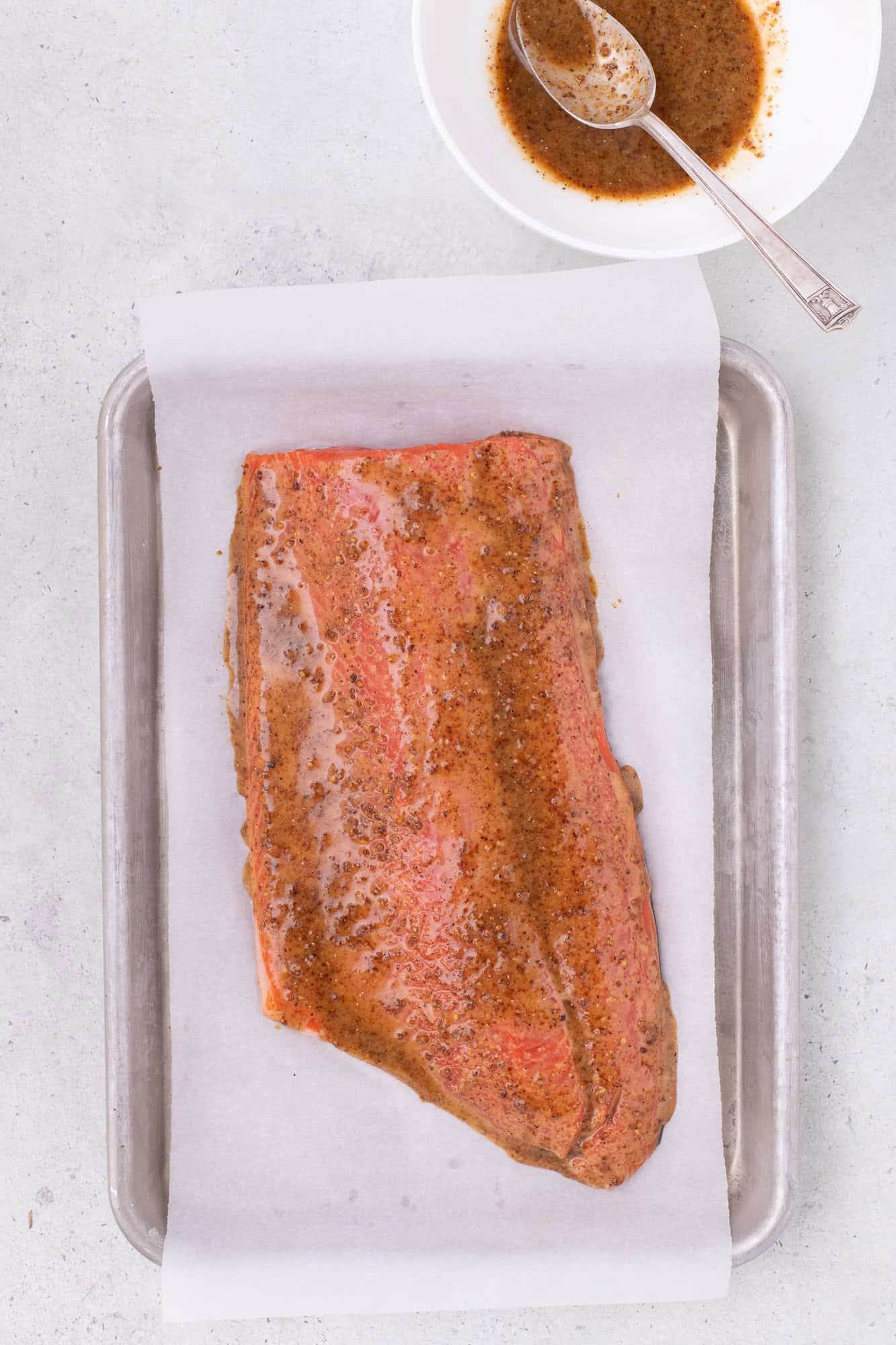Glaze added to salmon, not yet cooked.