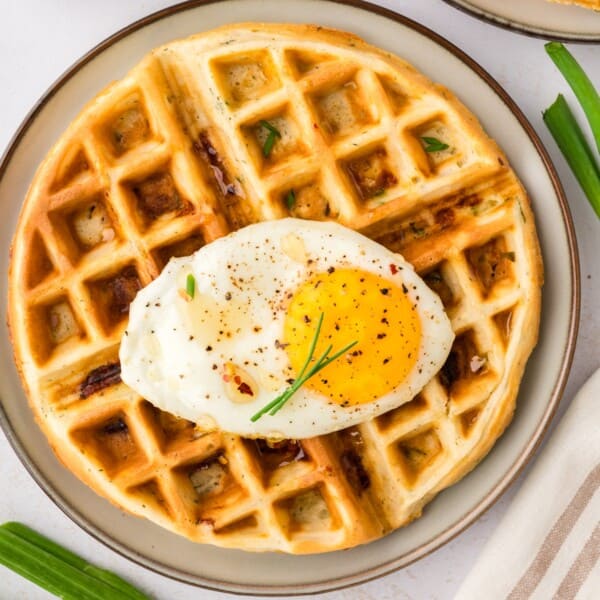 Overhead view of savory waffle topped with a fried egg.