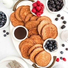 Chocolate protein pancakes spread out on a platter.