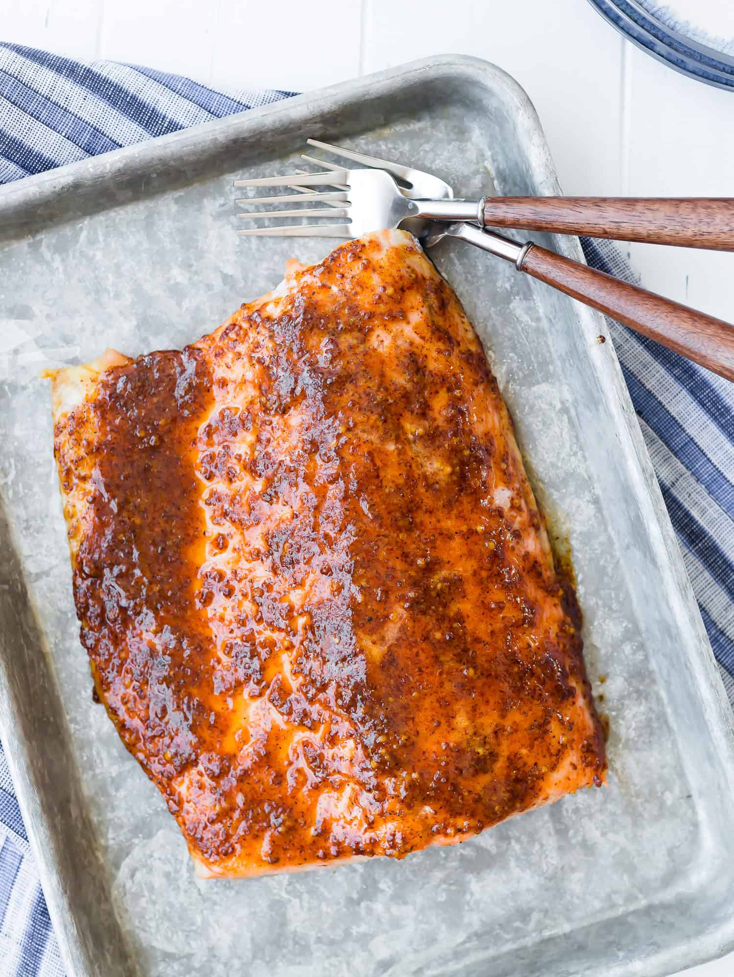 This is the best baked salmon recipe coated in a sweet and spicy maple mustard glaze. It's a healthy weeknight meal with only 5 ingredients! Overhead view of maple mustard baked salmon on a sheet pan.