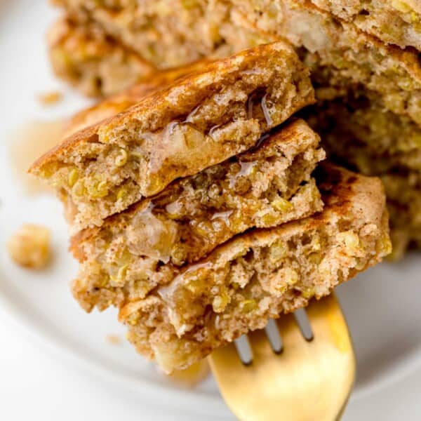 Apple quinoa pancakes on a fork with syrup.