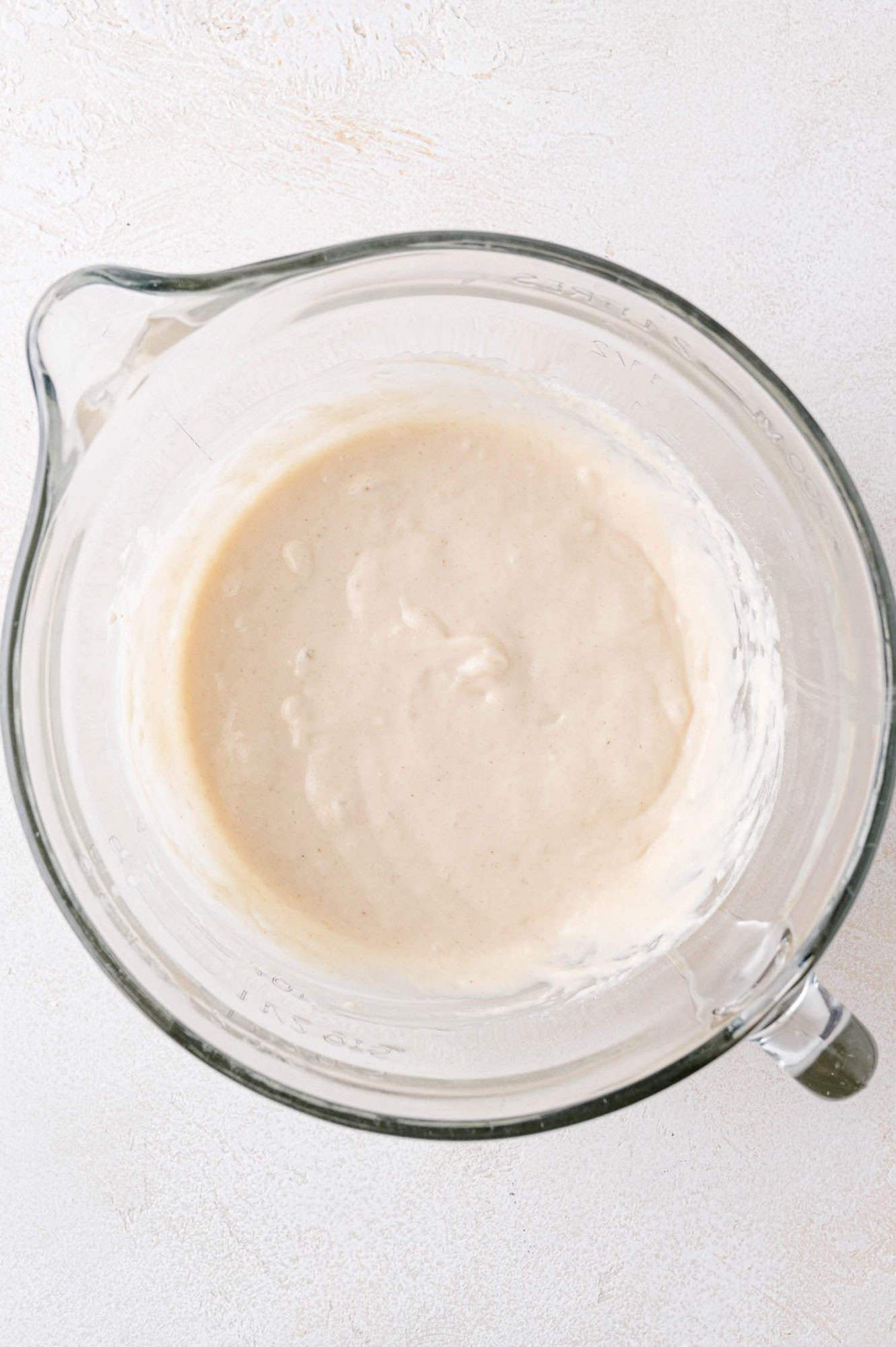 Completed buttermilk pancakes batter in a clear glass bowl.