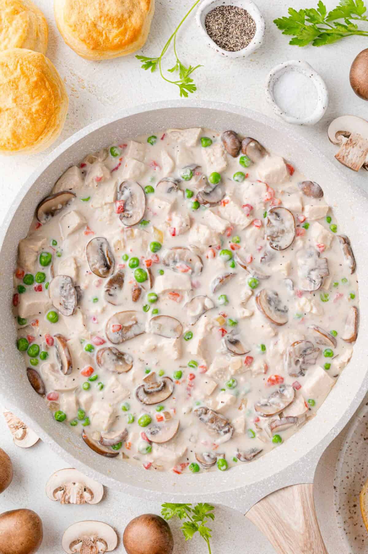 Completed chicken a la king in a white frying pan.