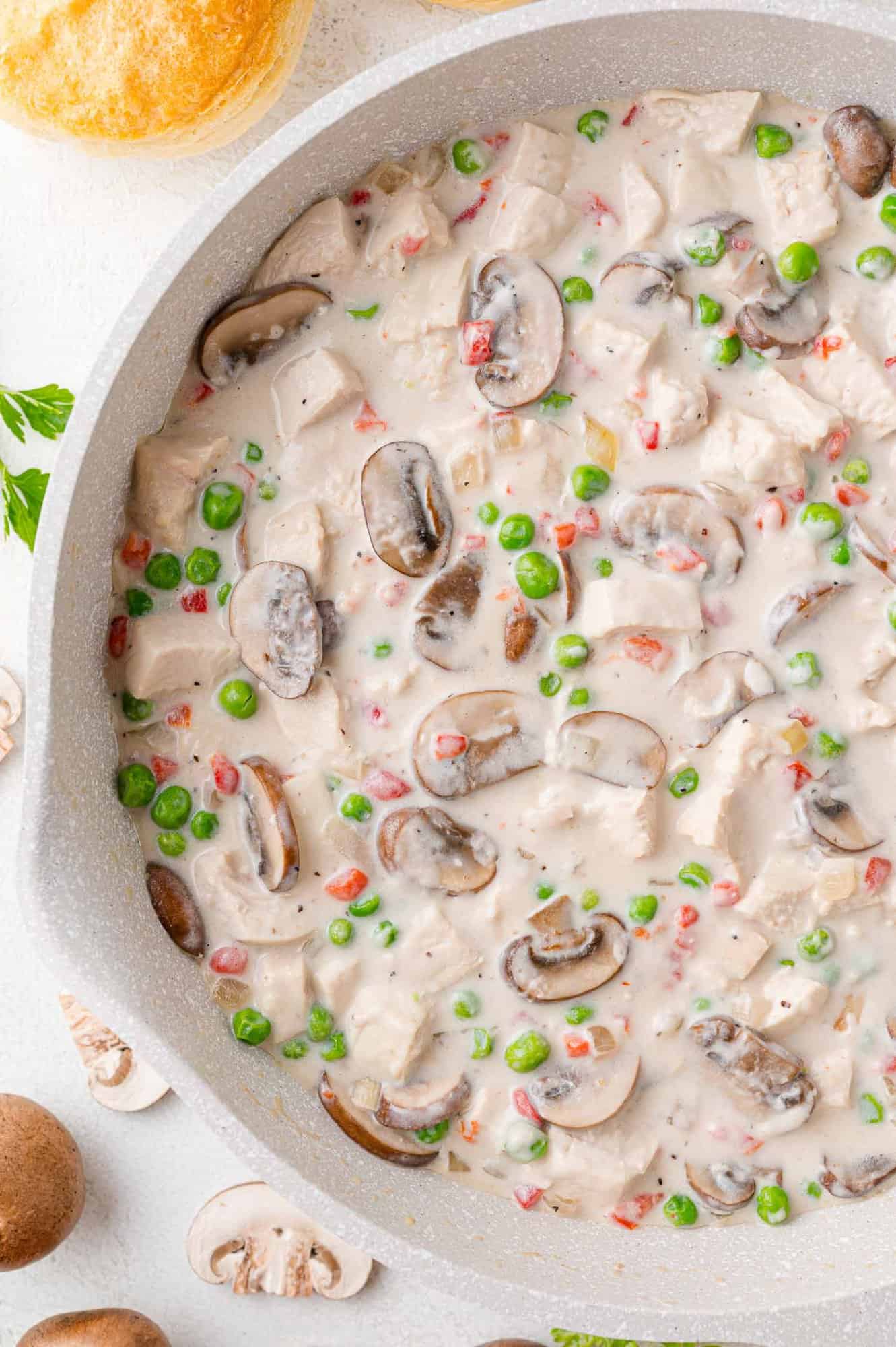 Chicken ala king in a white skillet.