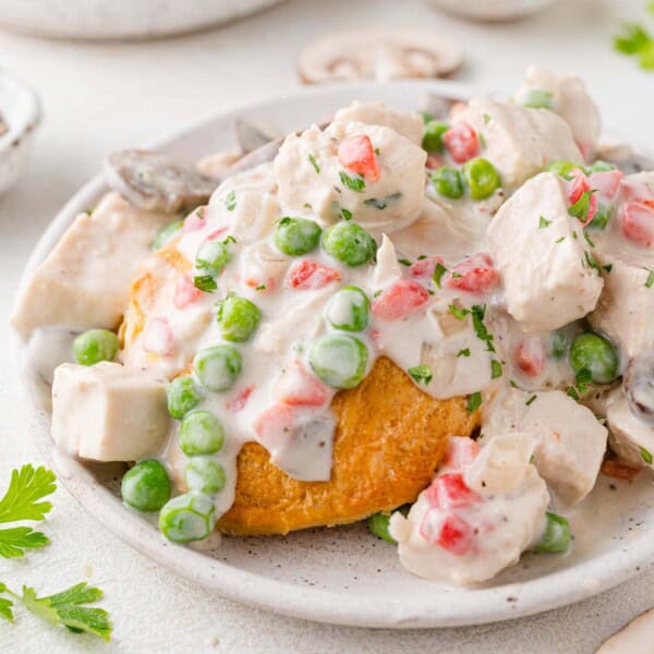 Chicken a la king, served over biscuits, on a white plate.