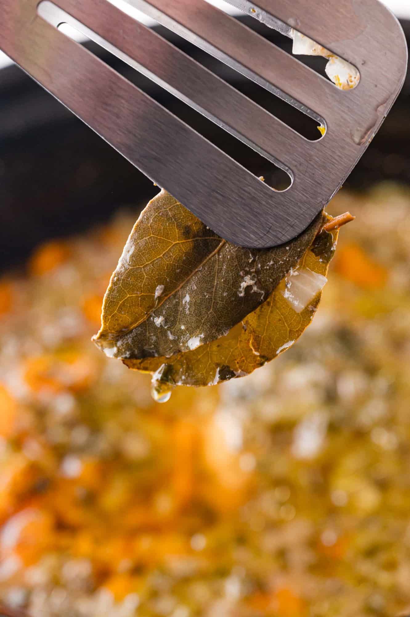 Bay leaf being removed from the soup.