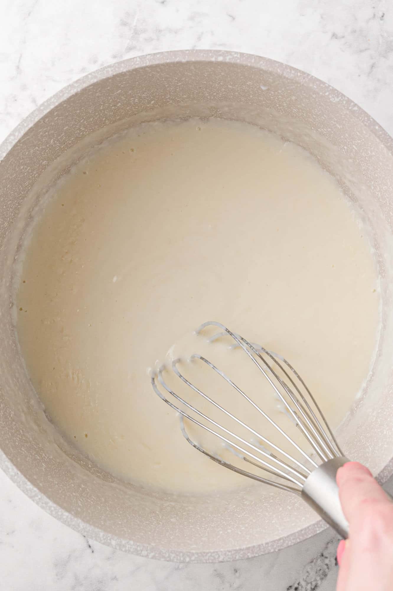 White sauce being made with a whisk.