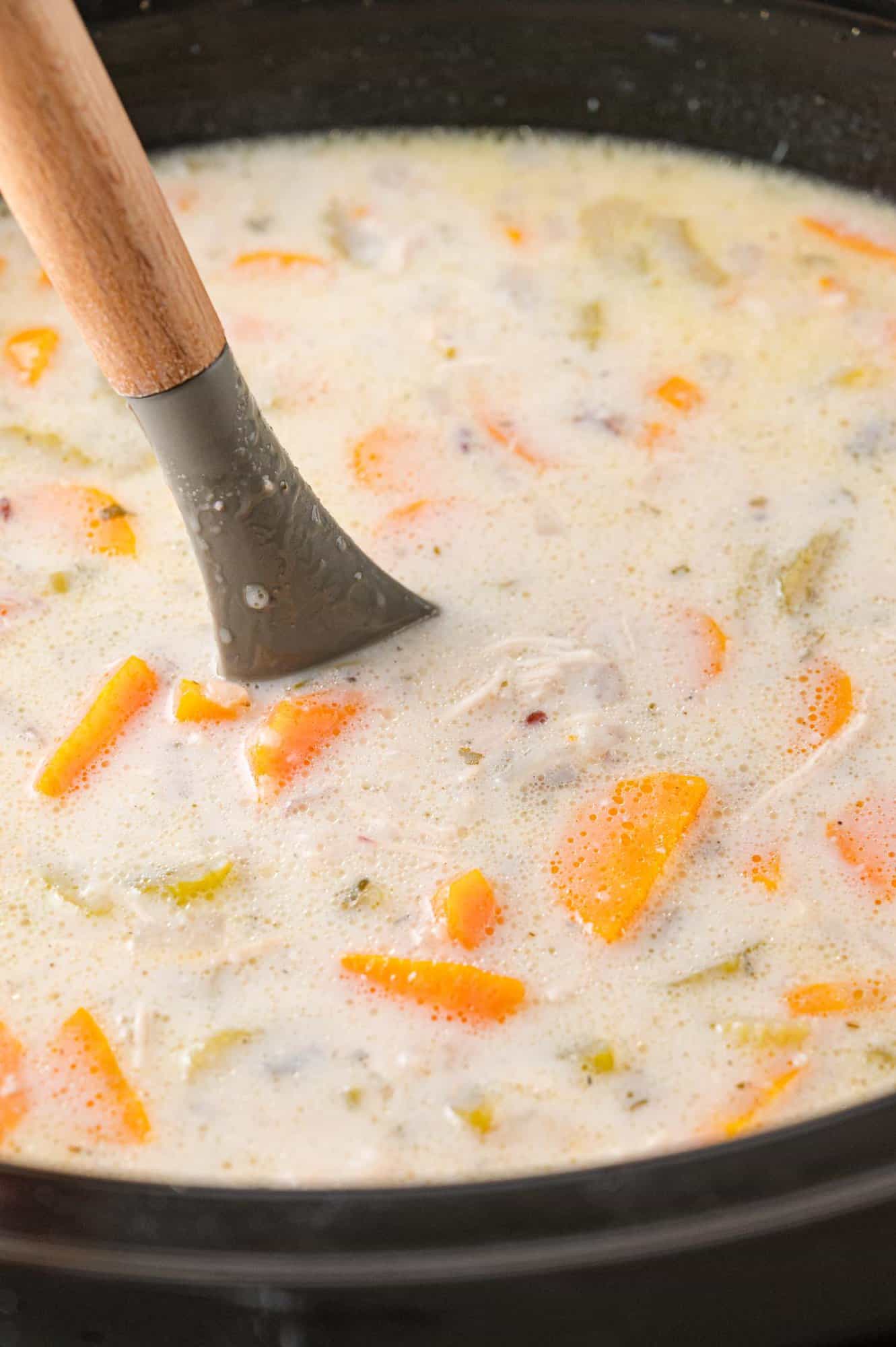 White sauce being stirred into the soup.
