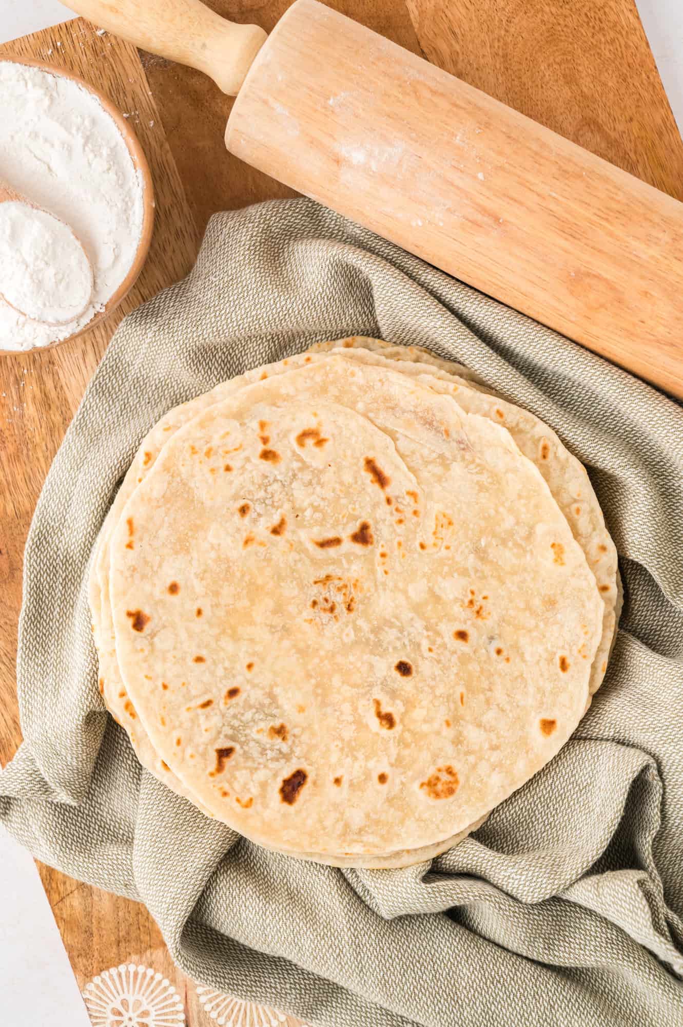 Overhead view of tortillas on a green cloth.