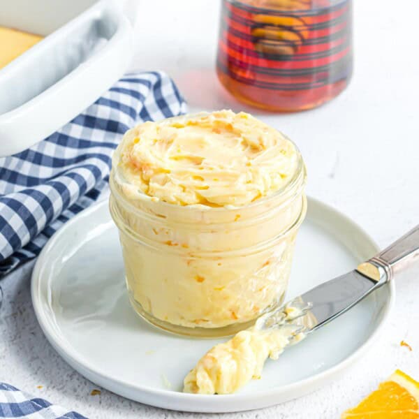 Orange honey butter in a small glass jar.