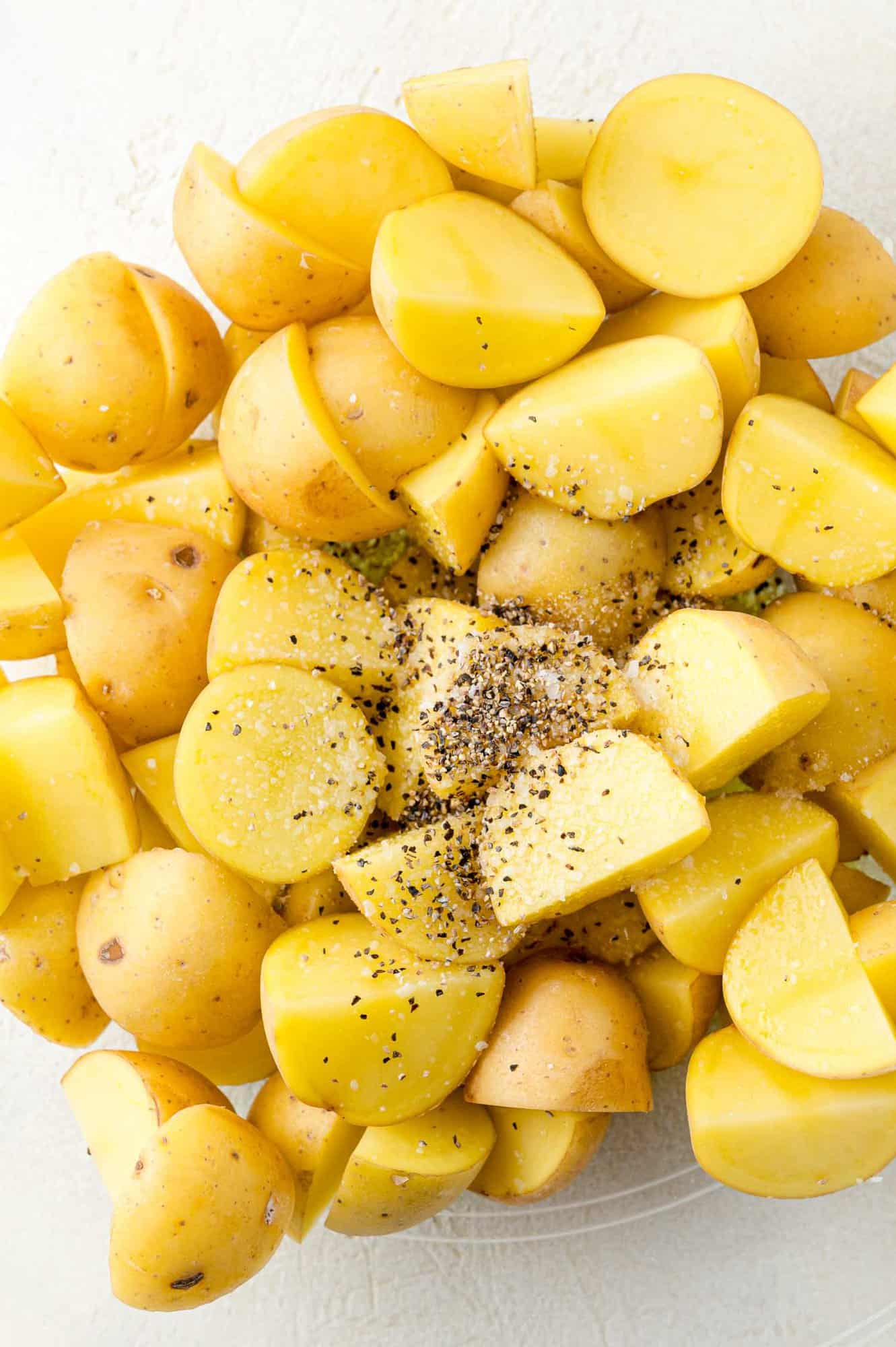 Salt, pepper, and olive oil added to potatoes.