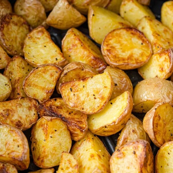 Air fryer potatoes, browned and still in air fryer basket.