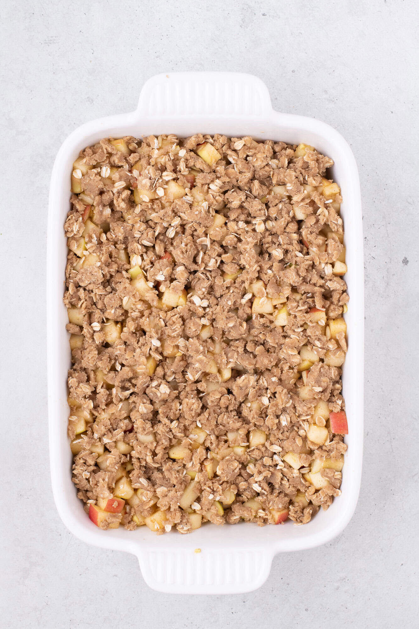 Unbaked apple crisp in casserole dish.