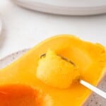 Crockpot butternut squash being scooped from the peel of squash.