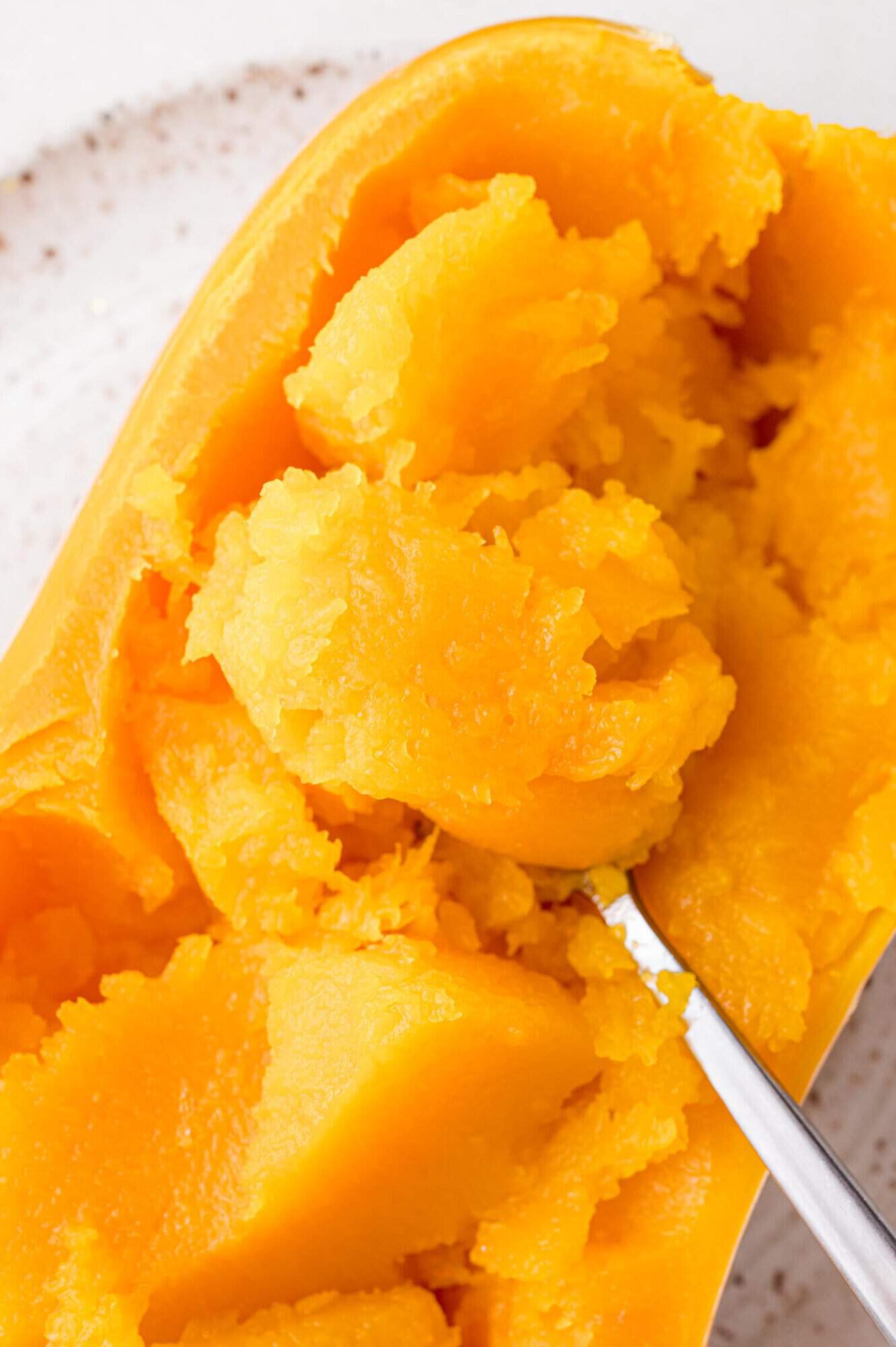 Flesh of squash being scooped out.