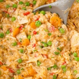 Crockpot chicken and rice casserole being scooped with a serving spoon.