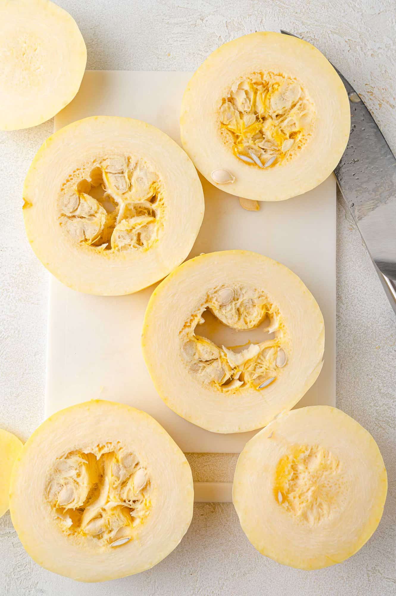 Spaghetti squash cut into rings, seeds not yet removed.