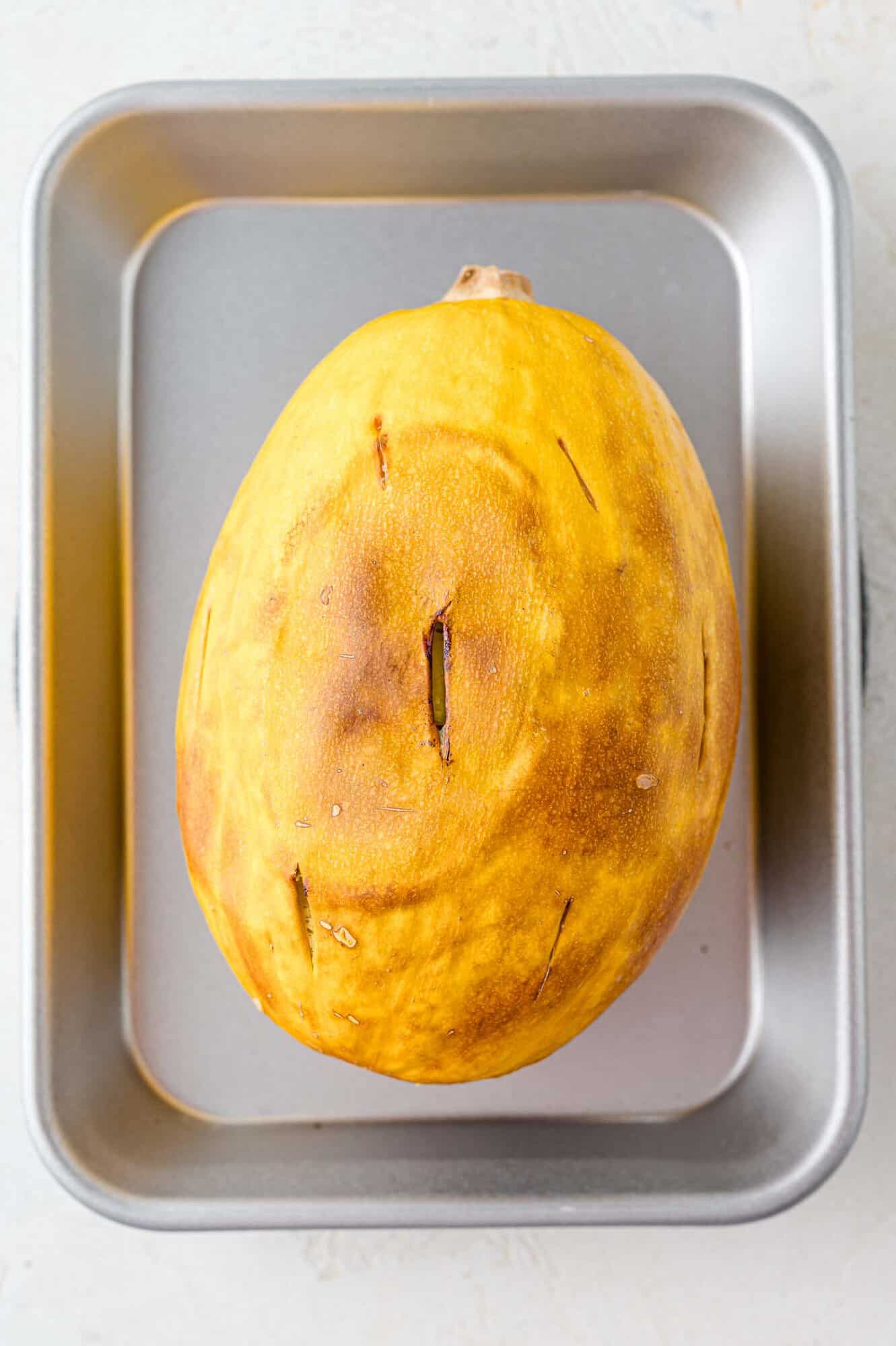 Baked whole spaghetti squash on a sheet pan.