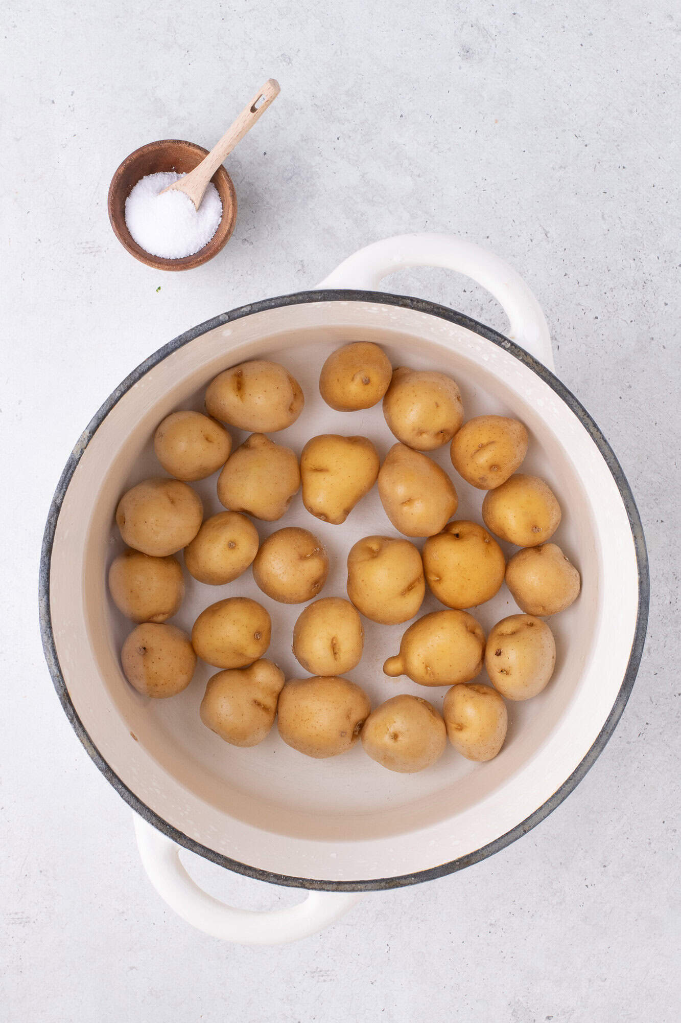 Baby potatoes being boiled in a large pot.