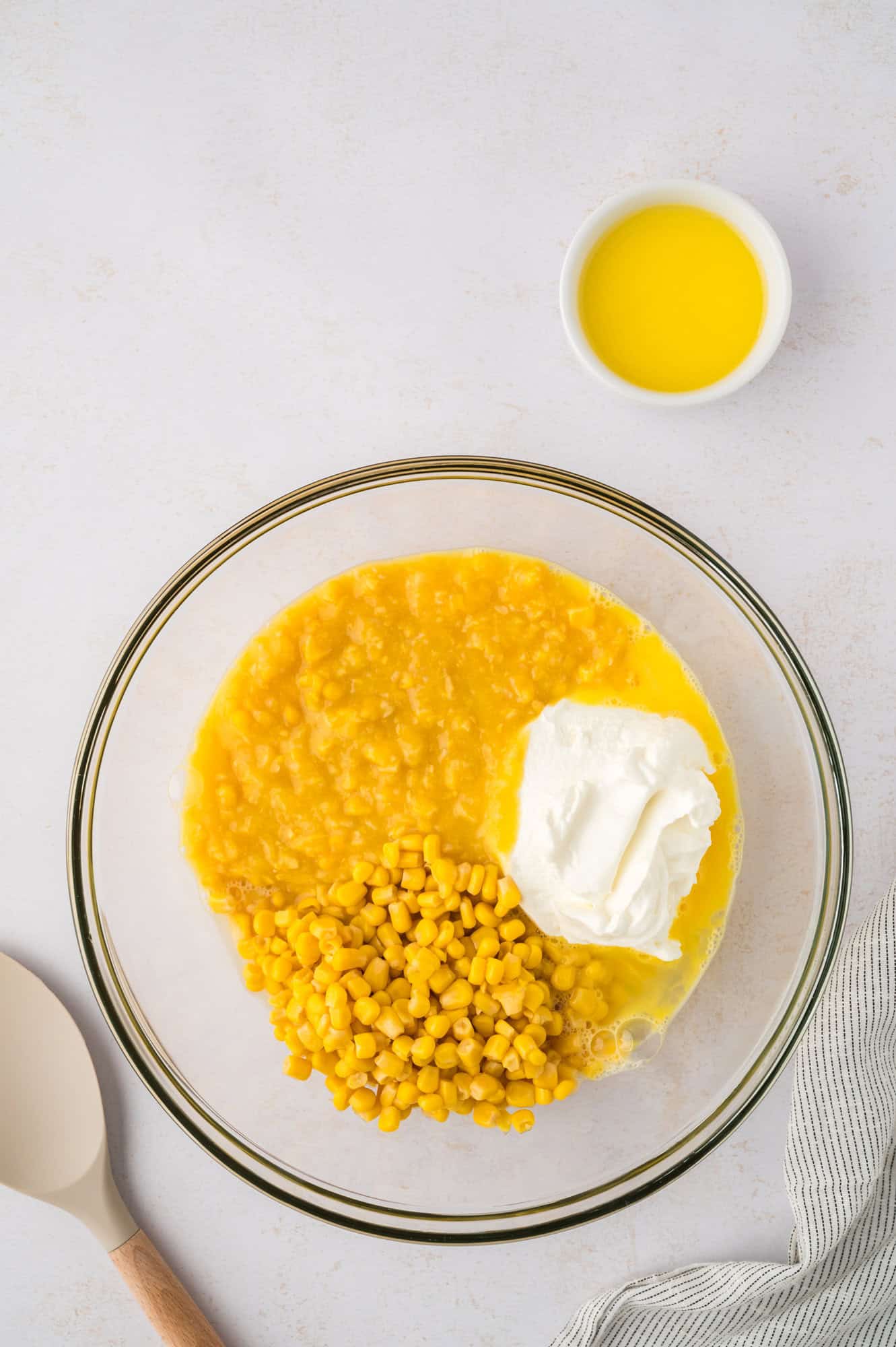 Corn and sour cream added to mixing bowl.