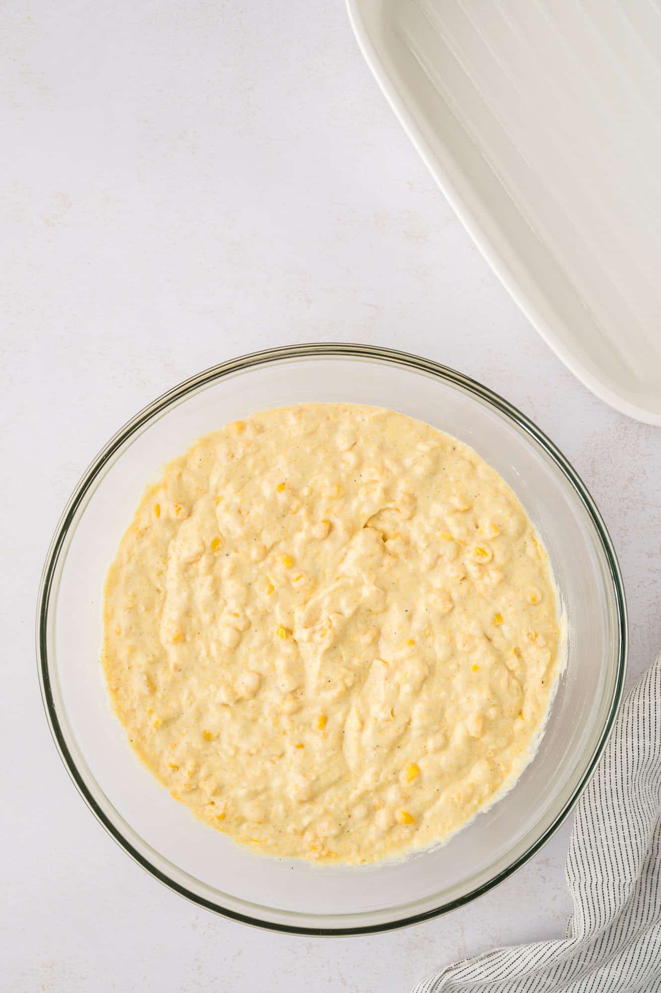 Completed spoon bread batter, still in clear glass mixing bowl.