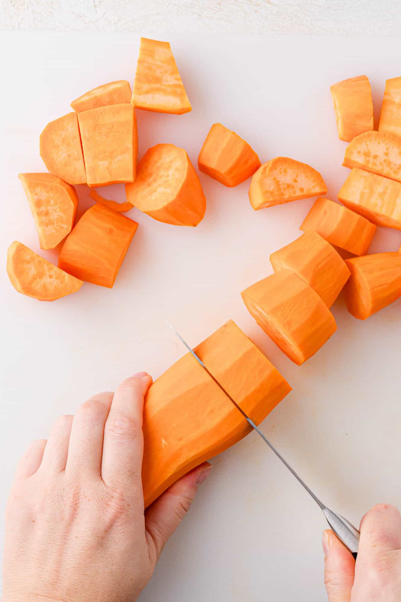 Sweet potato being cut into chunks.