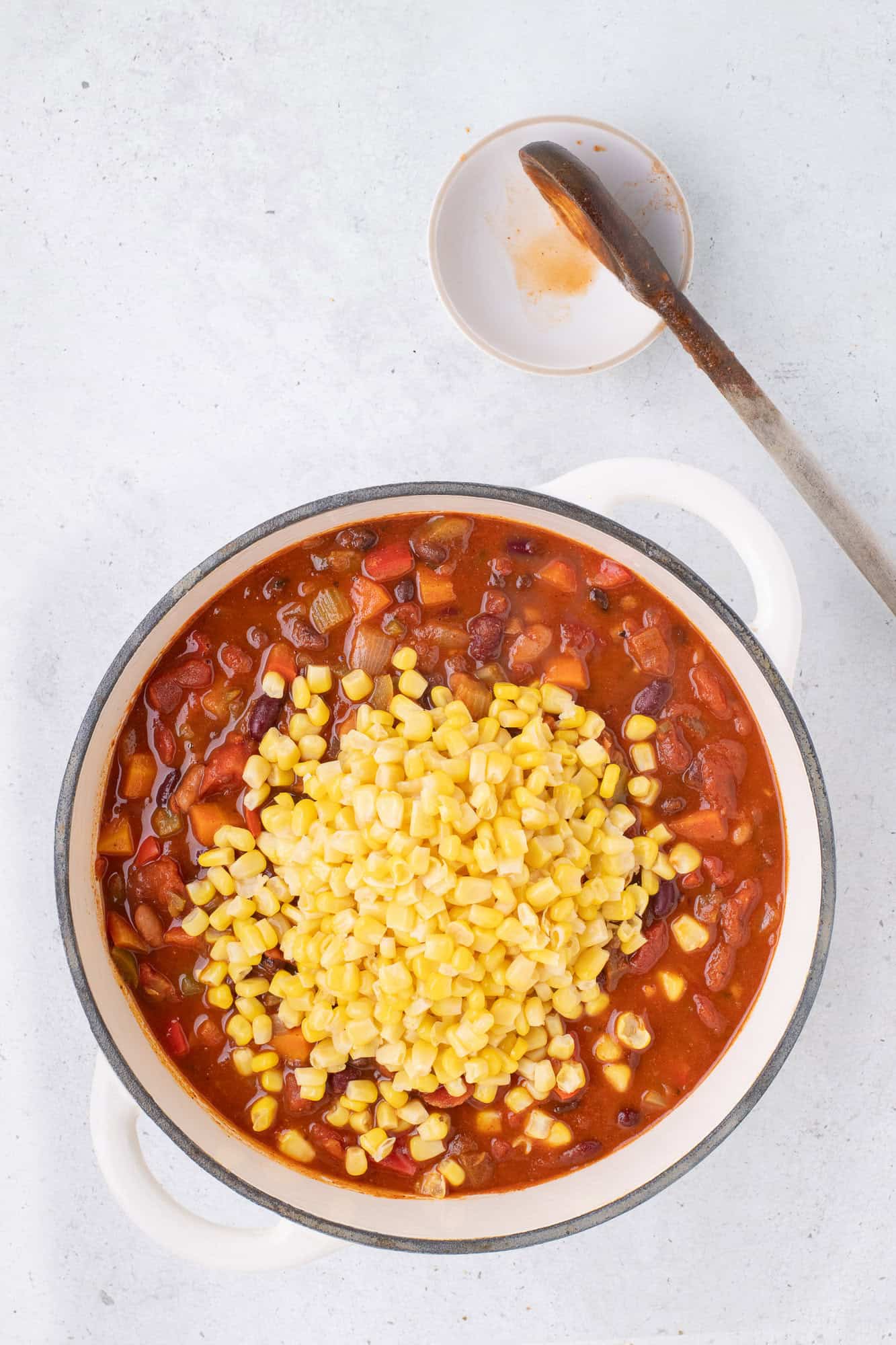 Corn added to chili, not yet stirred in.