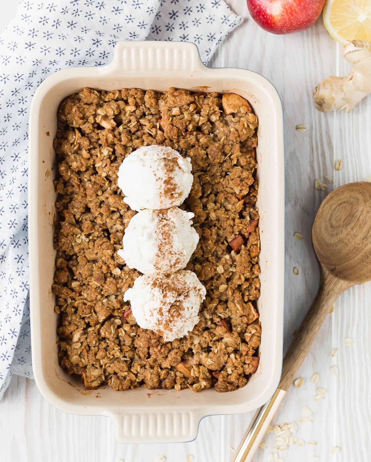 Overhead view of apple crisp in casserole dish, topped with ice cream.