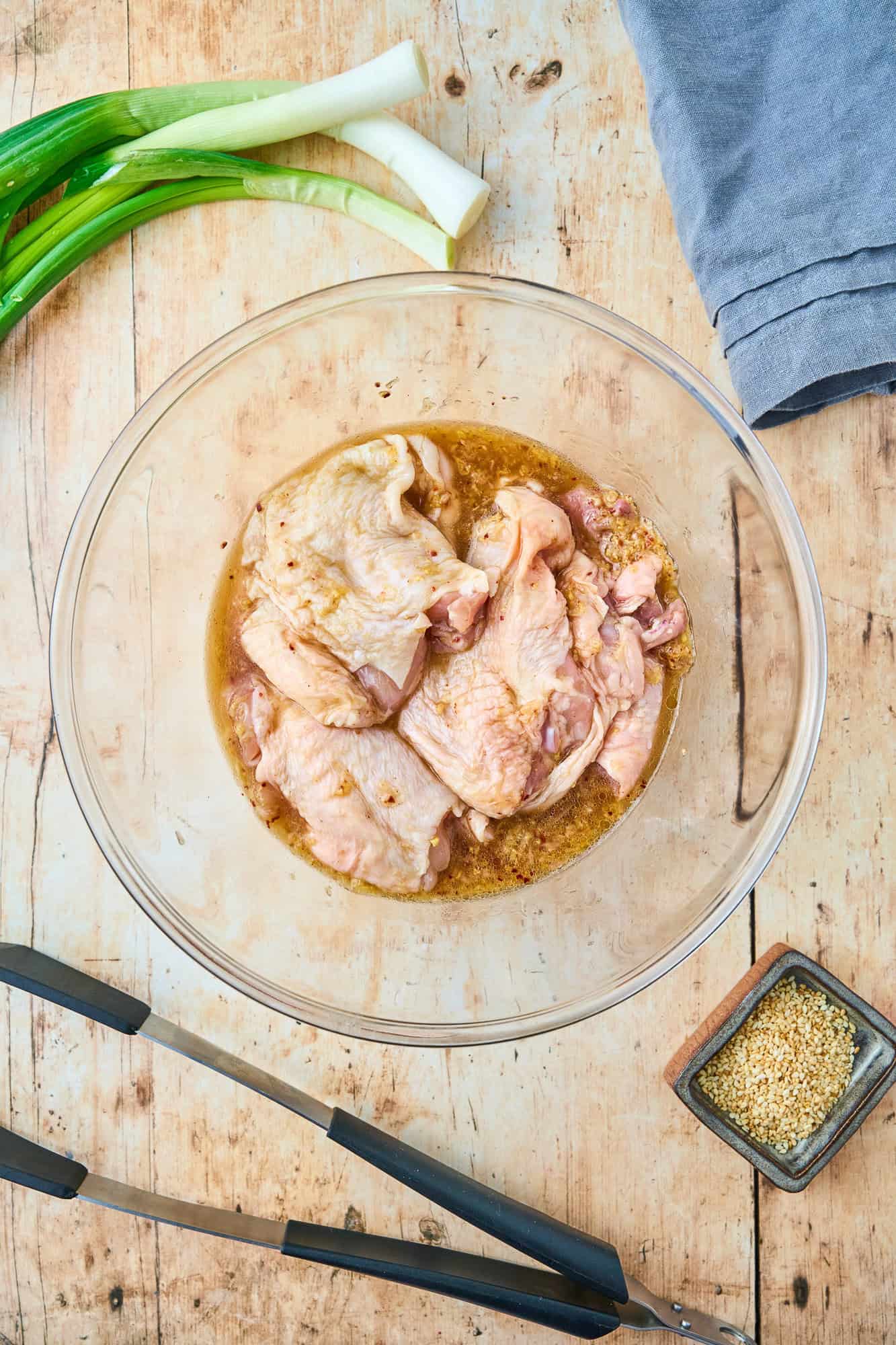 Chicken thighs placed in marinade.