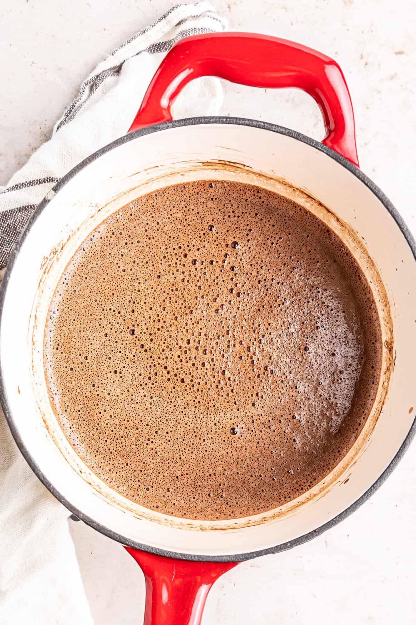 Oat milk hot chocolate, in a small red saucepan.