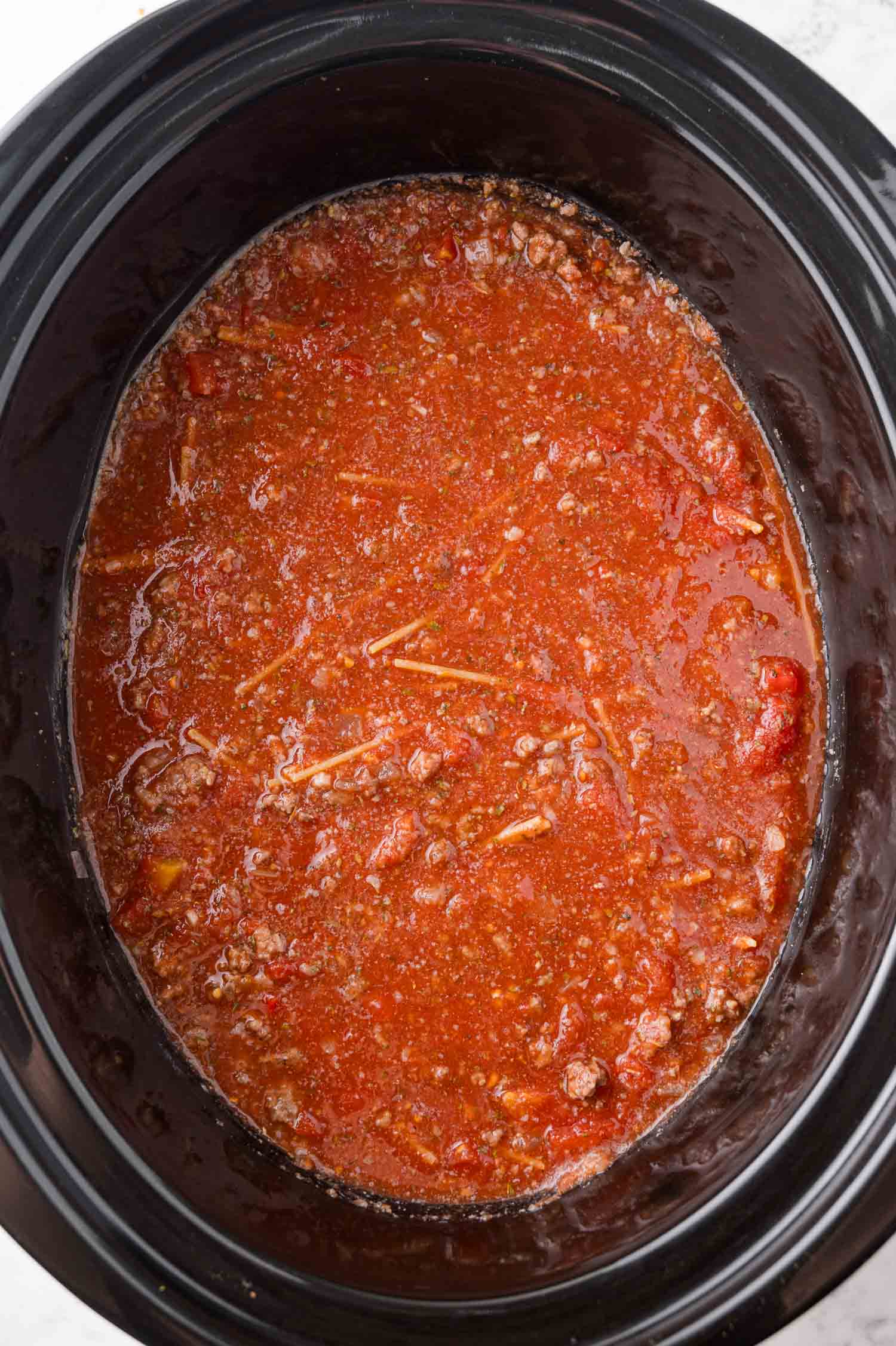 Slow cooker spaghetti, mixed together, before cooking.