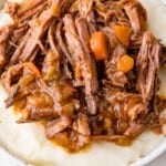Shredded braised beef with carrots and spices served on a bed of mashed potatoes.
