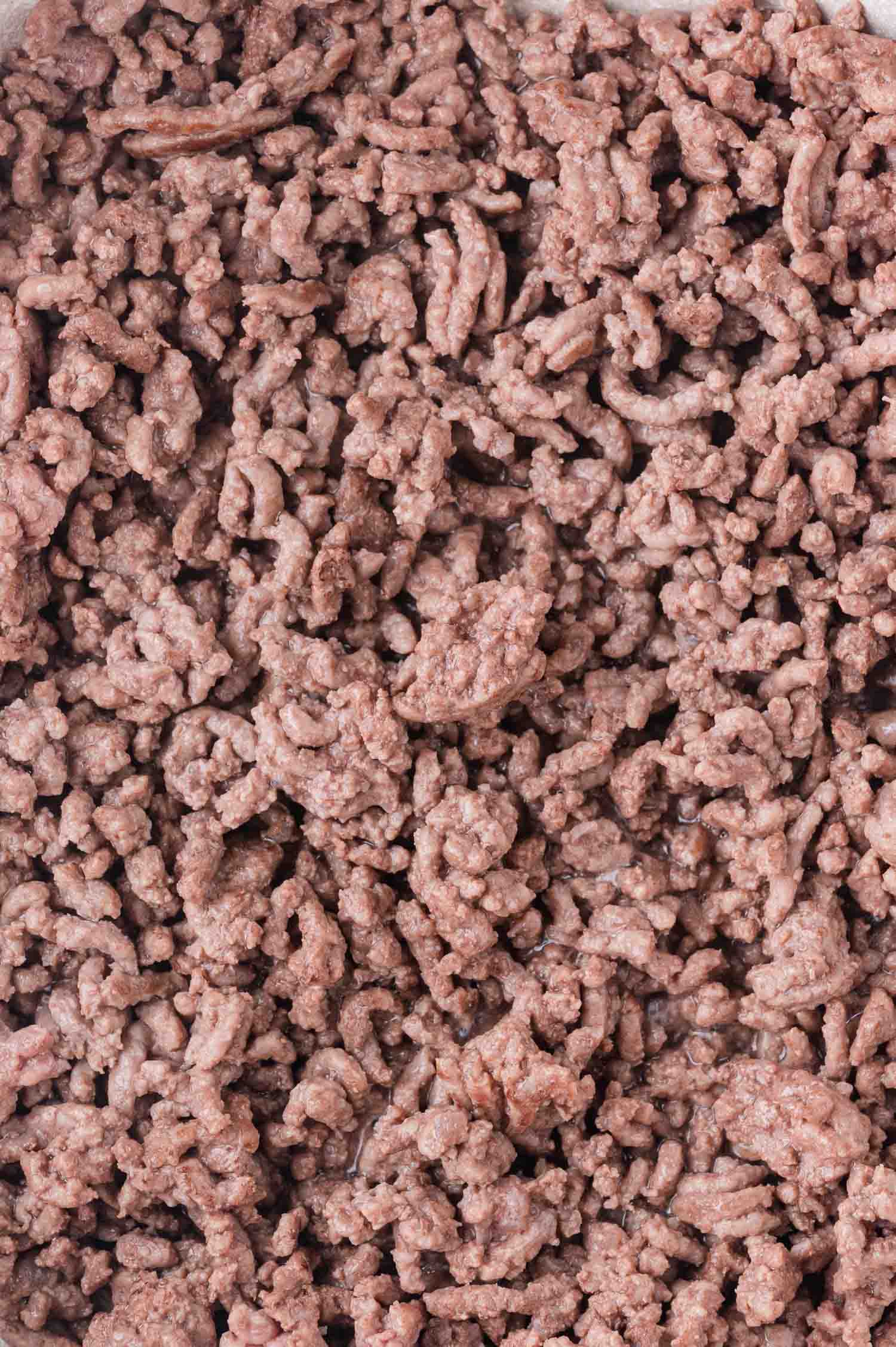Close-up view of cooked ground beef, showing small crumbled pieces with a light brown color.
