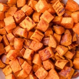 Close-up of roasted sweet potato cubes with a slightly crispy, browned exterior.